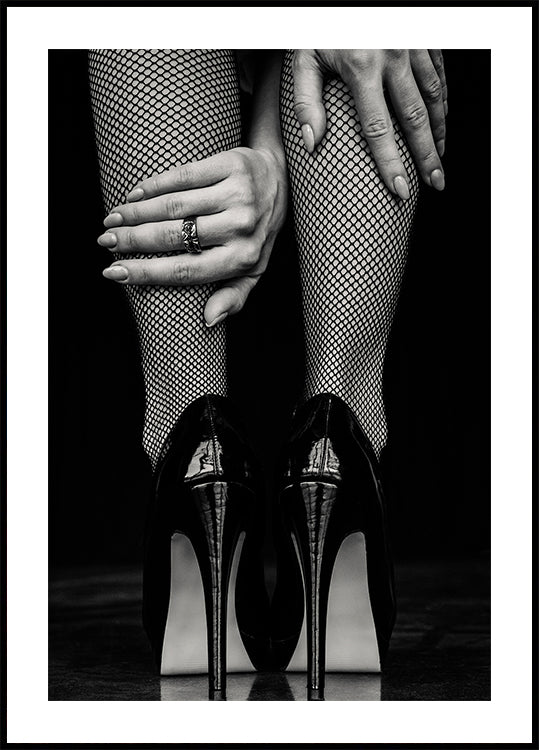 a black and white photo of a woman's legs with fishnet stockings and